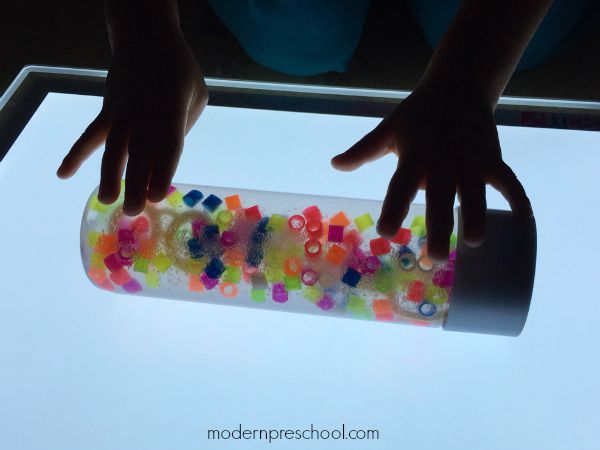 Rainbow Discovery Bottle filled with bubbles and beads for colorful, bubbly sensory light play from Modern Preschool