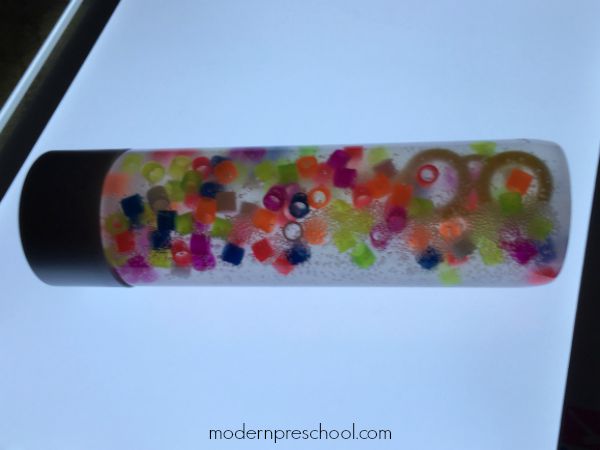 Rainbow Discovery Bottle filled with bubbles and beads for colorful, bubbly sensory light play from Modern Preschool