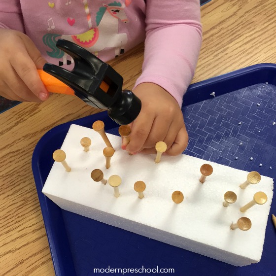 Let's go fine motor ice picking in preschool! Work on fine motor skills and hand-eye coordination with golf tees, hammers, and block of ice.