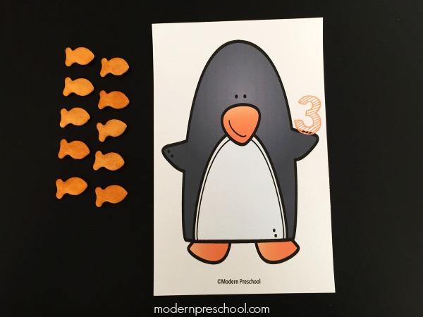Free printable winter themed penguin counting mats 1-10 for preschoolers to snack and learn! Practice numbers, 1:1 correspondence, & fine motor skills!